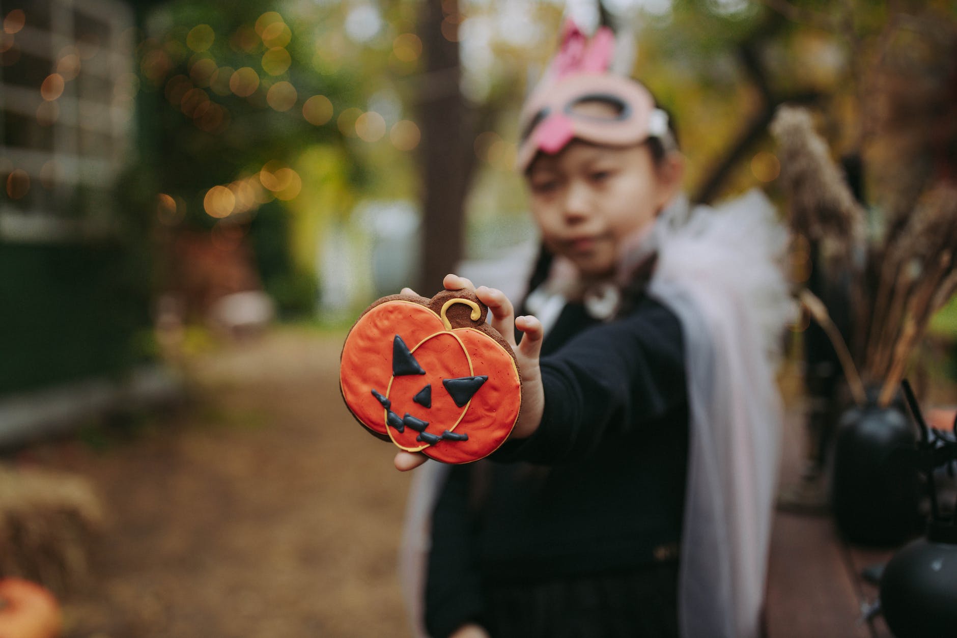 boy in black suit holding jack o lantern cookie