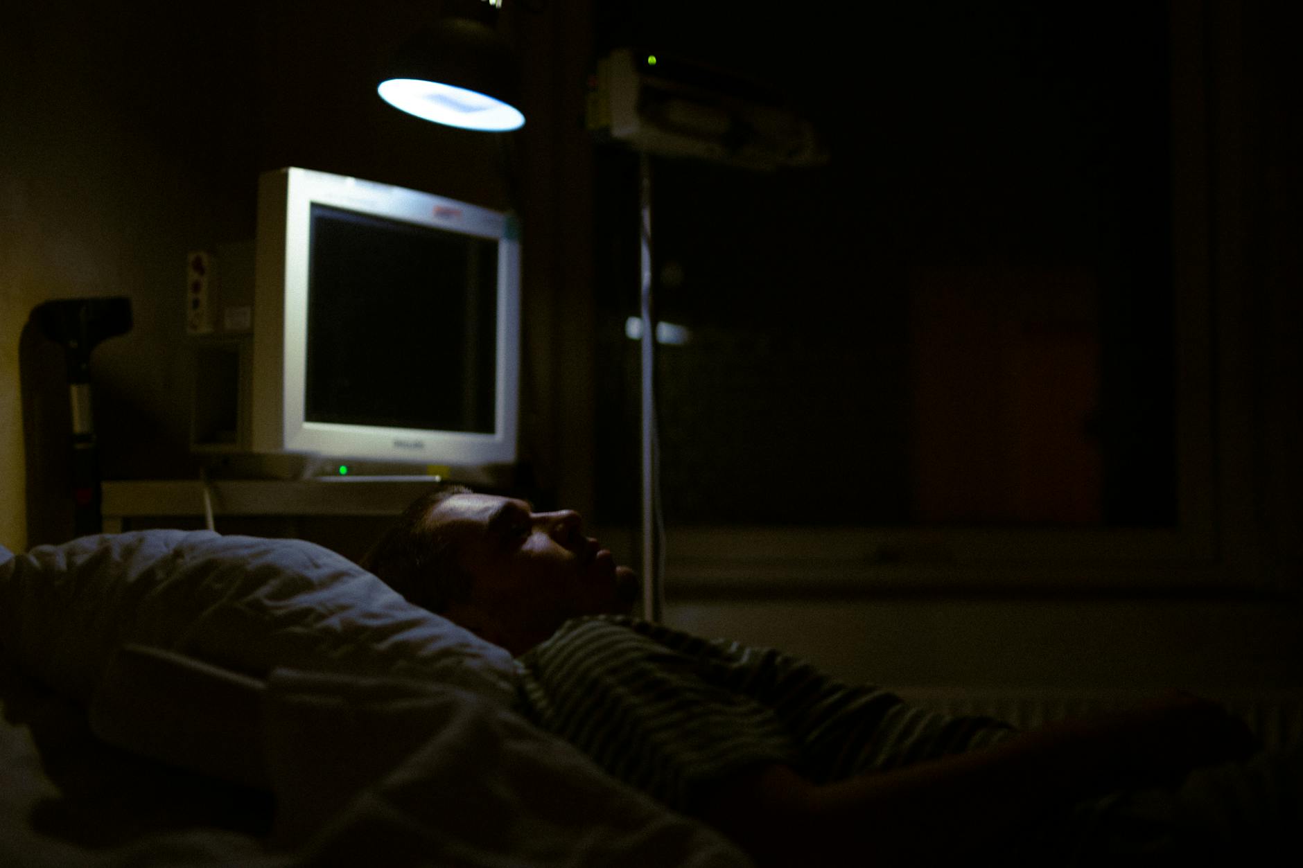 man lying on bed in the hospital